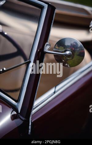Nahaufnahme eines runden Rückspiegels auf einem Oldtimer. Stockfoto