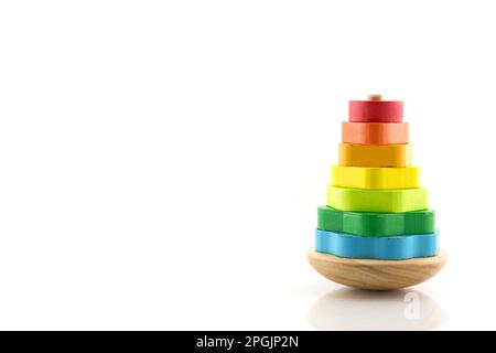 Pyramide aus farbigen Holzringen gebaut. Spielzeug für Babys und Kleinkinder, um spielend mechanische Fähigkeiten und Farben zu erlernen. Isoliert auf weißem Hintergrund. Stockfoto