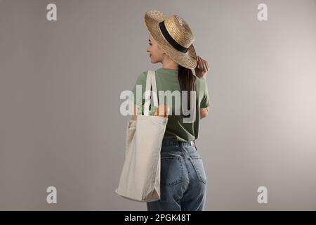 Frau mit einer Öko-Tasche voller Produkte auf hellem Hintergrund Stockfoto