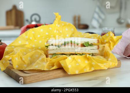 Leckeres Sandwich in Bienenwachs auf einem weißen Marmortisch Stockfoto