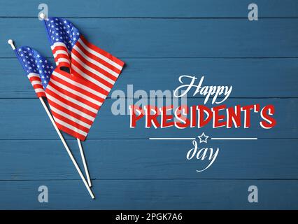 Alles gute zum President's Day - Bundesfeiertag. Amerikanische Flaggen und Text auf blauem Holztisch, flach liegend Stockfoto