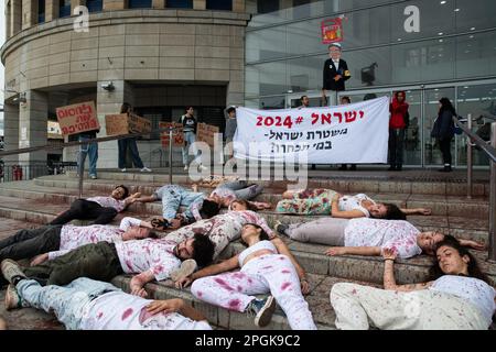 Anti-Reform-Protest vor der Polizeistation Tel Aviv in Tel Aviv, Israel am 23. März 2023. Die Demonstranten gegen die Gesetzesüberholung sind tot in einer Kunsteinrichtung vor dem Polizeihauptquartier von Tel Aviv. Sie fordern die Polizei auf, sich nicht dem Druck von Itamar Ben Gvir zu ergeben. minister für nationale Sicherheit, der von der israelischen Polizei verlangt, entschlossen gegen die Proteste im ganzen Land vorzugehen. Die Demonstranten wurden verhaftet. Manche halten ein Schild mit Itamar Ben Gvir in der Hand, mit einer Waffe und einem Tank voller Treibstoff, auf dem "Pyroman" steht. (Foto: Matan Golan/Sipa USA) Stockfoto
