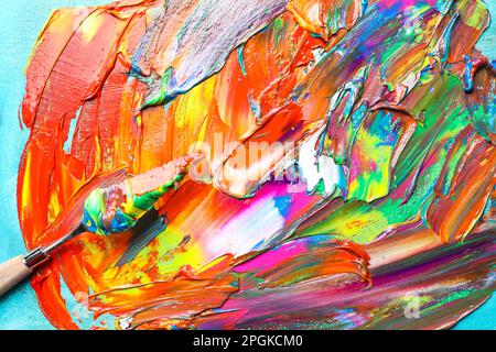 Bunte Acrylfarben und Malmesser auf Leinwand, Draufsicht Stockfoto