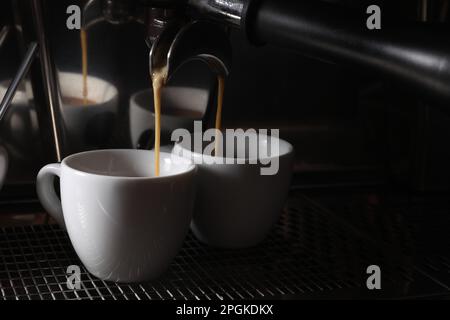 Zubereitung von frischem aromatischem Espresso mit einer professionellen Kaffeemaschine im Café, Nahaufnahme. Platz für Text Stockfoto