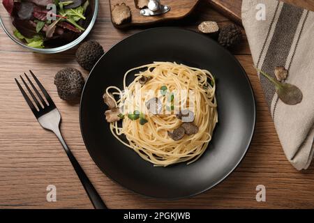 Leckere Spaghetti mit Trüffel, serviert auf einem Holztisch, flach liegend Stockfoto