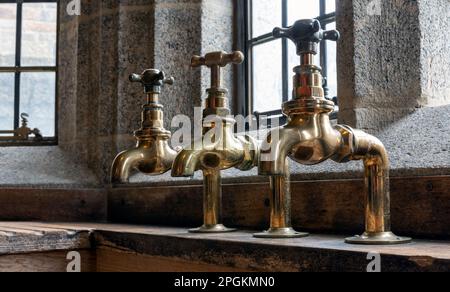 Messing-Wasserhähne in Castle Dropo, Drewsteignton, Devon, England, Großbritannien Stockfoto