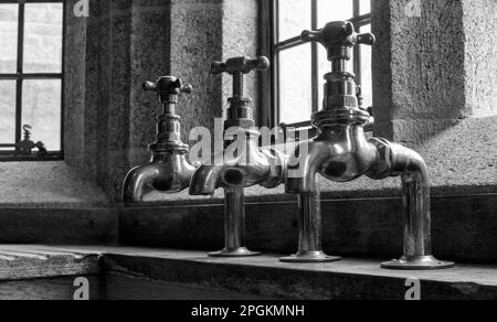 Messing-Wasserhähne in Castle Dropo, Drewsteignton, Devon, England, Großbritannien Stockfoto