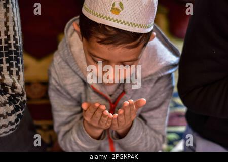 Srinagar, Indien. 23. März 2023. Ein junger kaschmirischer muslimischer Junge betet in der Großen Moschee oder Jamia Masjid während des ersten Tages des heiligen muslimischen Monats Ramadan in Srinagar. (Foto: Saqib Majeed/SOPA Images/Sipa USA) Guthaben: SIPA USA/Alamy Live News Stockfoto