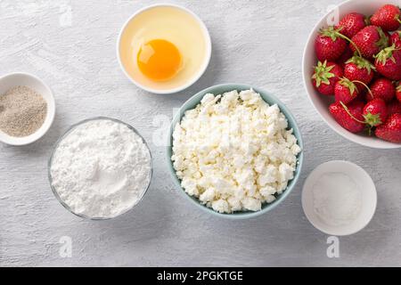 Zutaten für hausgemachten Hüttenkäse-Gnocchi mit Erdbeersauce: Hüttenkäse, Erdbeere, Reismehl, Ei, Zucker, Vanillezucker, Backpulver Stockfoto