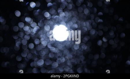 Vollmond warf um Mitternacht ein Fenster voller Wassertropfen. Sterne sind Bokeh oder die Bokehs sind Wassertropfen. Licht am Ende des Tunnels. Nach dem Leben. Stockfoto