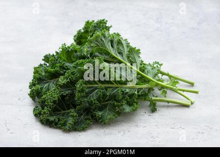 Frische grüne Grünkohl-Blätter auf hellgrauem Hintergrund. Superfood, Diät, gesundes Essen Stockfoto