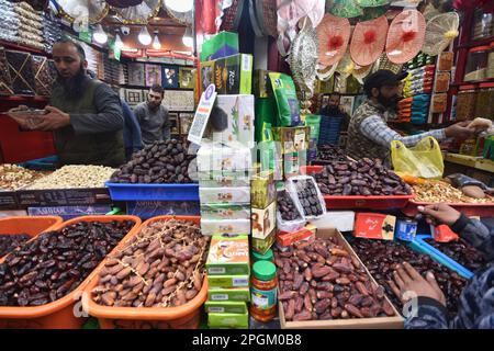 Srinagar, Indien. 23. März 2023. Ein Ladenbesitzer, der am 23. März 2023 auf einem Markt in Srinagar Dates verkauft, wartet auf seine Kunden, da Menschen Lebensmittel kaufen, um während des heiligen muslimischen Fastenmonats im Ramadan zu essen. (Foto von Mubashir Hassan/Pacific Press) Kredit: Pacific Press Media Production Corp./Alamy Live News Stockfoto