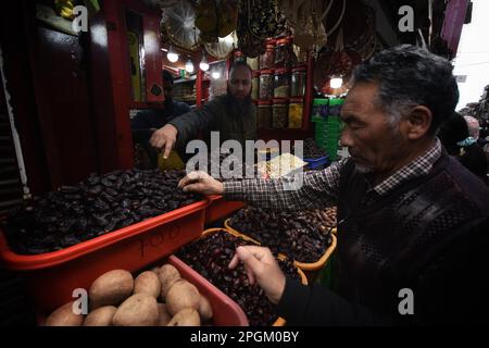 Srinagar, Indien. 23. März 2023. Ein Ladenbesitzer, der am 23. März 2023 auf einem Markt in Srinagar Dates verkauft, wartet auf seine Kunden, da Menschen Lebensmittel kaufen, um während des heiligen muslimischen Fastenmonats im Ramadan zu essen. (Foto von Mubashir Hassan/Pacific Press) Kredit: Pacific Press Media Production Corp./Alamy Live News Stockfoto