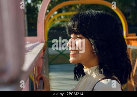 Glückliche junge latina, lächelnd auf der Brücke, Profilansicht, Lifestyle-Konzept. Stockfoto