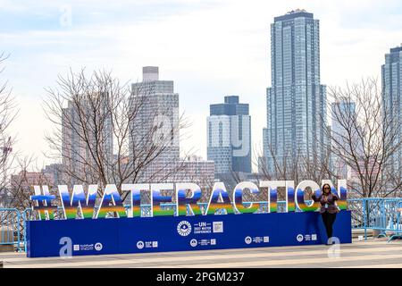 New York, USA. 23. März 2023. Die Teilnehmer posieren neben einem #WATERACTION-Schild, das während der UN-Wasserkonferenz 2023 vor dem Hauptquartier der Vereinten Nationen aufgestellt wurde. Delegierte aus 196 Ländern und internationalen Organisationen sprechen auf der 3-tägigen Konferenz der Vereinten Nationen über die umfassende Halbzeitüberprüfung der Umsetzung der Ziele der Internationalen Aktionsdekade „Wasser für nachhaltige Entwicklung“ (2018-2028). Kredit: Enrique Shore/Alamy Live News Stockfoto