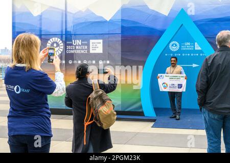 New York, USA. 23. März 2023. Die Teilnehmer machen Fotos vor einem Display, das während der UN-Wasserkonferenz 2023 am Eingang des Hauptquartiers der Vereinten Nationen aufgestellt wurde. Delegierte aus 196 Ländern und internationalen Organisationen sprechen auf der 3-tägigen Konferenz der Vereinten Nationen über die umfassende Halbzeitüberprüfung der Umsetzung der Ziele der Internationalen Aktionsdekade „Wasser für nachhaltige Entwicklung“ (2018-2028). Kredit: Enrique Shore/Alamy Live News Stockfoto