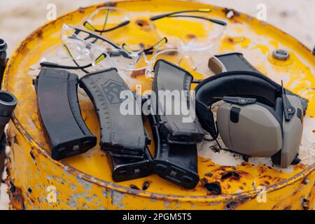 Es gibt Magazine von Kalaschnikov Sturmgewehr auf dem Metallfass, geschossen von einer Schusswaffe auf einem Schießstand. Nahaufnahme. Stockfoto