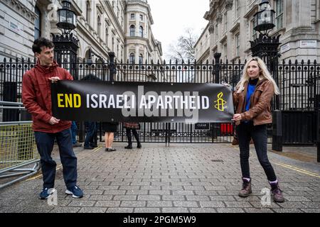 London, Großbritannien. 23. März 2023 Demonstranten demonstrieren außerhalb der Downing Street mit einer Botschaft „Ende der israelischen Apartheid“ auf einer von Amnesty International UK organisierten Veranstaltung. Der israelische Premierminister Benjamin Netanjahu wird morgen Rishi Sunak zu Gesprächen in der Downing Street treffen. Kredit: Stephen Chung / Alamy Live News Stockfoto