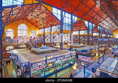 BUDAPEST, UNGARN - 22. FEBRUAR 2022: Die zentrale Markthalle mit Metallsäulen, Pavillons mit Verkaufsständen und Geschäften, am 22. Februar in Budapest Stockfoto