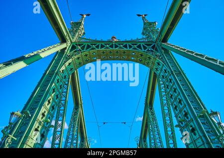 Die Schnitzereien und skulpturierten Dekorationen der Freiheitsbrücke im Jugendstil vor dem hellblauen Himmel, Budapest, Ungarn Stockfoto