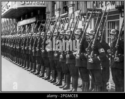 Leibstandarte SS Adolf Hitler SS-Stabswache at Attention in Hakenkreuzarmband und Jackstiefeln 1935, eine ausgewählte Einheit von Adolf Hitlers persönlicher Garde, begrüßt den polnischen Außenminister Józef Beck vor dem Bahnhof. Die 1. SS-Panzerdivision Leibstandarte SS Adolf Hitler oder SS-Division Leibstandarte, abgekürzt LSSAH, begann als persönliche Leibwache Adolf Hitlers, die für die Bewachung der Person des Führers, der Büros und Wohnungen zuständig war Veranstaltungsdatum: 1935-07 Ort: Berlin Nazi Deutschland Stockfoto