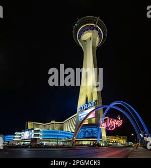 Ein Bild von STRAT Hotel, Casino und SkyPod und Las Vegas Boulevard Gateway Arches bei Nacht. Stockfoto