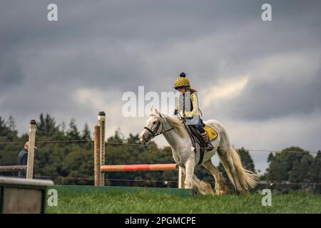 Ein junges Mädchen reitet auf einem Pferd über springende Zäune. 41. Uhr Johnstown Coolgreany Gymkhana & Field Day 2022. Co. Wexford. Irland Stockfoto