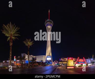 Ein Bild vom STRAT Hotel, Casino und SkyPod, den Las Vegas Boulevard Gateway Arches und der Kapelle der Glocken bei Nacht. Stockfoto