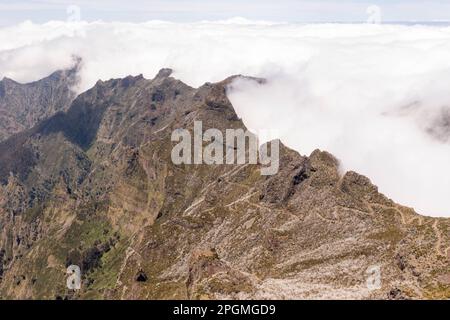 Drohnenfotografie von Berggipfeln und gestoppten Wolken durch die Bergkette an sonnigen Sommertagen. Großer Blickwinkel Stockfoto