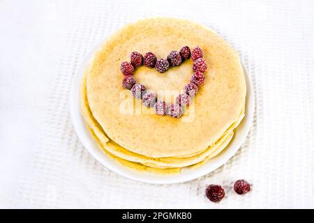 Himbeerherz auf Pfannkuchen Stockfoto