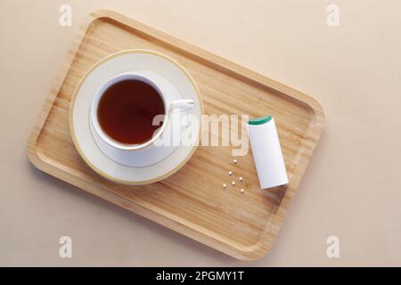 Künstlicher Süßstoffbehälter und Teetasse auf dem Tisch Stockfoto