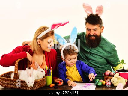 Mutter, Vater und Sohn bereiten sich auf Osterferien vor. Osterfamilientraditionen. Ostereier. Glückliche Eltern und ein kleiner Junge mit Hasenohren Stockfoto