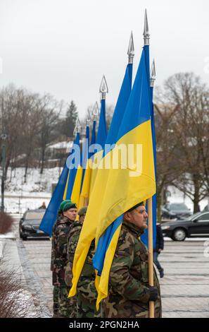 Soldatenruhe in Militäruniformen mit ukrainischen Flaggen, senkrecht Stockfoto