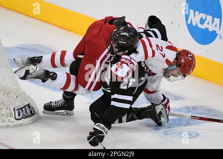 Manchester, New Hampshire, USA. 23. März 2023. Boston University Forward John Copeland (27) und Western Michigan Forward Jack Perbix (25) verwickeln sich im dritten Studienjahr in Manchester, New Hampshire, hinter dem Netz. Eric Canha/CSM/Alamy Live News Stockfoto