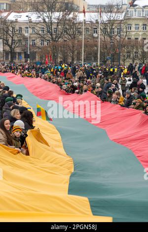 Vilnius Litauen - März 11 2022: Riesige litauische Flagge entlang der Gedimino Avenue in Vilnius, die von Menschen mit litauischen und ukrainischen Flaggen getragen wird Stockfoto