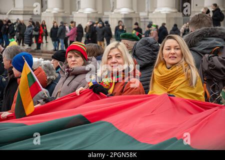 Vilnius Litauen - März 11 2023: Riesige litauische Flagge entlang der Gedimino Avenue in Vilnius, die von Frauen mit litauischen und ukrainischen Flaggen getragen wird Stockfoto