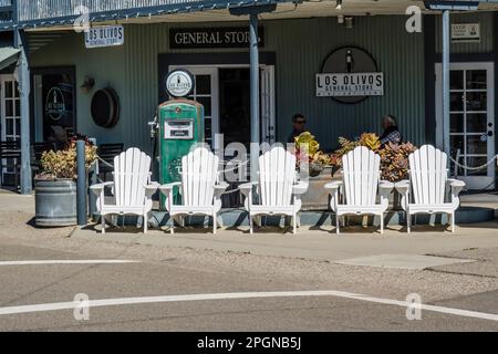 Fünf weiße Adirondack-Stühle stehen vor dem historischen Los Olivos General Store im Dorf Los Olivos, Kalifornien. Stockfoto