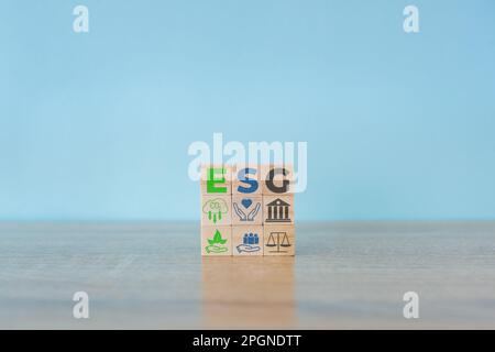 Holzwürfel mit der Abkürzung ESG auf blauem Hintergrund. ESG-Konzept von Umwelt, Soziales und Governance. Nachhaltige Unternehmensentwicklung Stockfoto