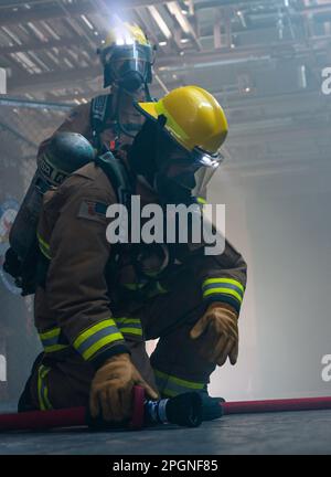 230322-N-VI040-1190 ATSUGI, Japan (22. März 2023) Kommandeur, Regionale Feuerwehr der Marine Japan (CNFJRFD), Naval Air Facility (NAF) Atsugi, Japan, Feuerwehrleute reagieren auf einen simulierten Brand während der Übung Reliant Gale 2023 an Bord der NAF Atsugi am 22. März 2023. Reliant Gale ist eine jährliche Übung, die dazu dient, den Stand der Notfallvorsorge, die Verantwortlichkeit des Personals sowie die Evakuierungs- und Wiederherstellungsmaßnahmen einer Anlage während einer Naturkatastrophe zu testen und zu bewerten. (USA Marinefoto von Mass Communication Specialist 2. Class Rafael Avelar) Stockfoto