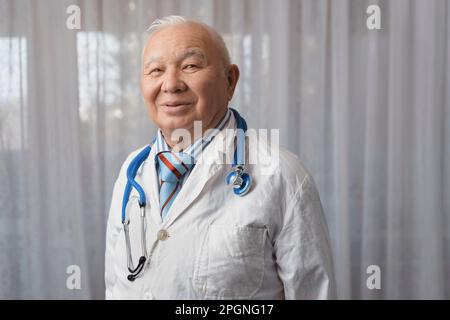 Glücklicher Arzt, der vor dem Fenster in der Klinik steht Stockfoto