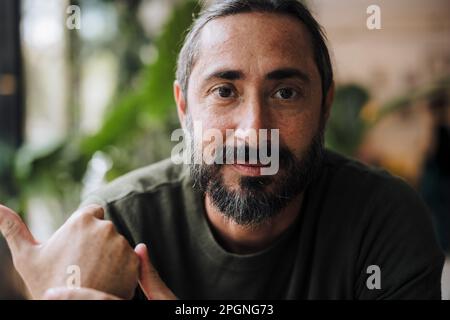 Reifer bärtiger Mann im Café Stockfoto
