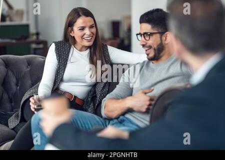 Fröhliche Kollegen führen gemeinsam Gespräche im Büro Stockfoto