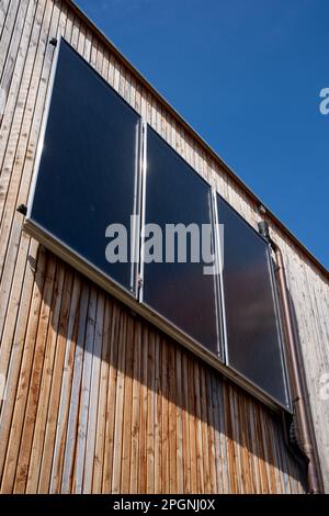 Sonnenkollektor an der Holzfassade Stockfoto