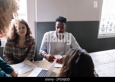 Geschäftsleute, die während einer Besprechung am Schreibtisch sitzen Stockfoto