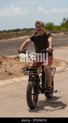 Westkap, Südafrika. 2023. Mann fährt ein Elektrofahrrad, macht eine Probefahrt. Stockfoto