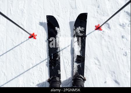 Ein Mann mit Skiern steht mit Stöcken im Schnee Stockfoto