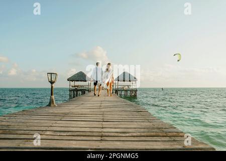 Ein junges Paar, das zusammen auf dem Pier spaziert Stockfoto