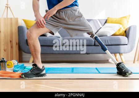 Mann mit amputierter Beindehnung im Wohnzimmer Stockfoto