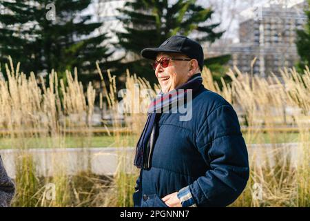 Ein glücklicher Senior-Mann, der im Park eine Jacke trägt Stockfoto