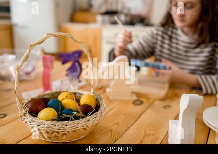 Farbenfrohe ostereier in Korb auf dem Tisch zu Hause Stockfoto